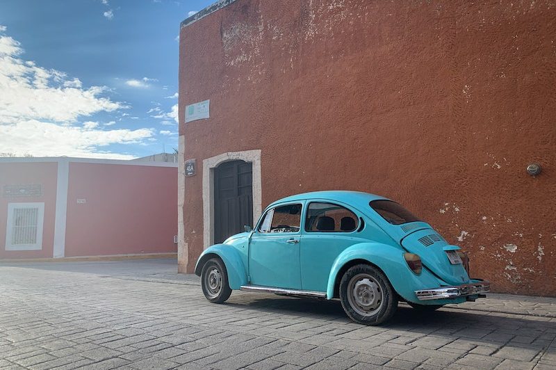 Ein türkisfarbener VW Käfer in den Straßen von Valladolid