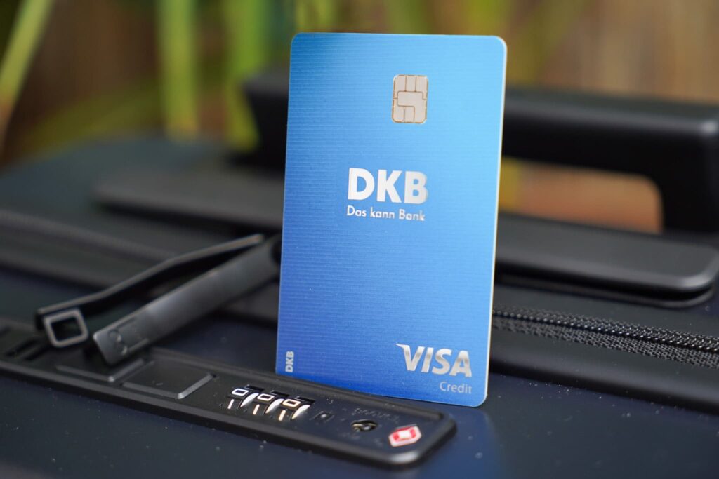 Eine DKB Reisekreditkarte steht auf einem Koffer von Level 8. Mit der Kreditkarte der DKB kann man Mietwagen ausleihen, da es eine echte Kreditkarte mit einem Verfügungsrahmen ist.