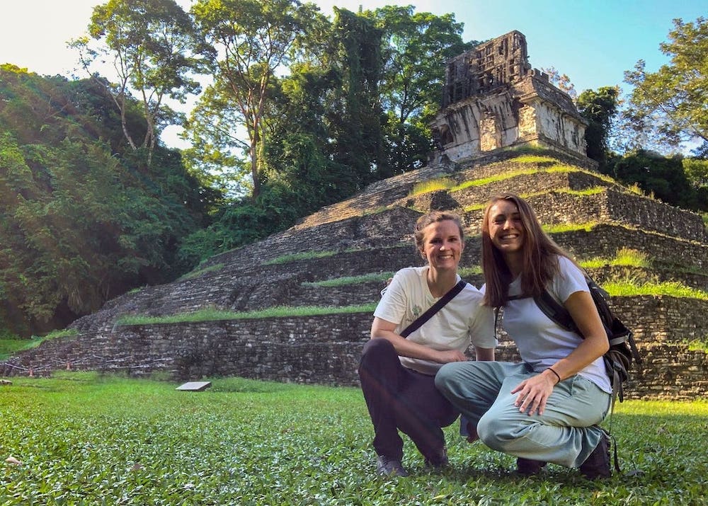 Zwei Frauen hocken vor der Maya Ruine in Palenque. Sie tragen helle Kleidung, welches ein guter Mückenschutz für Mexiko ist. Außerdem haben sie sich mit Mückenspray eingesprüht