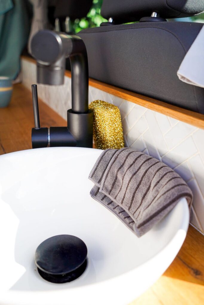 Der Goldschwamm und das Antibac Tuch   hängen über einem kleinen Waschbecken in einem Wohnmobil. In unserem Test haben sich die Produkte von EASYCLEAN als sehr gute Wohnmobil Reiniger erwiesen. das Beste: Sie kommen ganz ohne Chemie aus