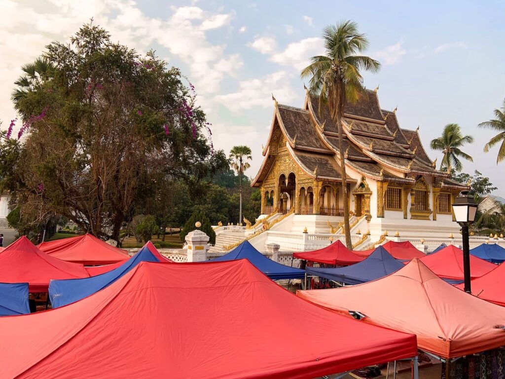 Rote und blaue Zelten des Nachtmarktes in Luang Prabang sind vor dem Königspalast aufgebaut. Der Nachtmarkt ist eine Sehenswürdigkeit in Luang Prabang und wird täglich vor dem Königspalast aufgebaut