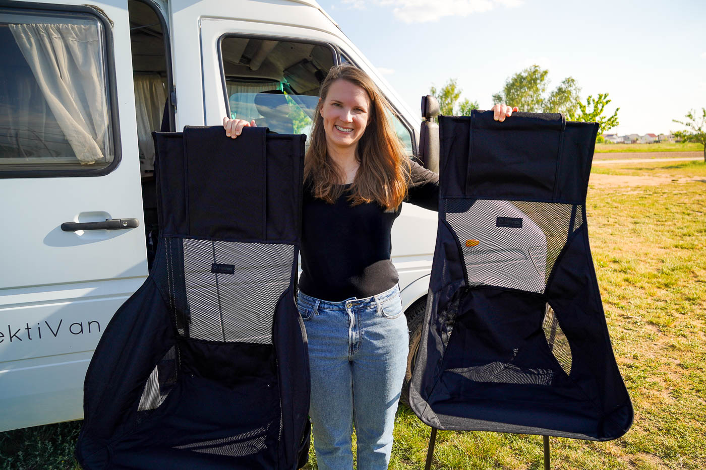 Einen Frau hält zwei Campingstühle von Helinox in der Hand. In der linken Hand den Helinox Savanna und in der rechten den Helinox Sunset, so kann man die Stühle im direkten Vergleich sehen